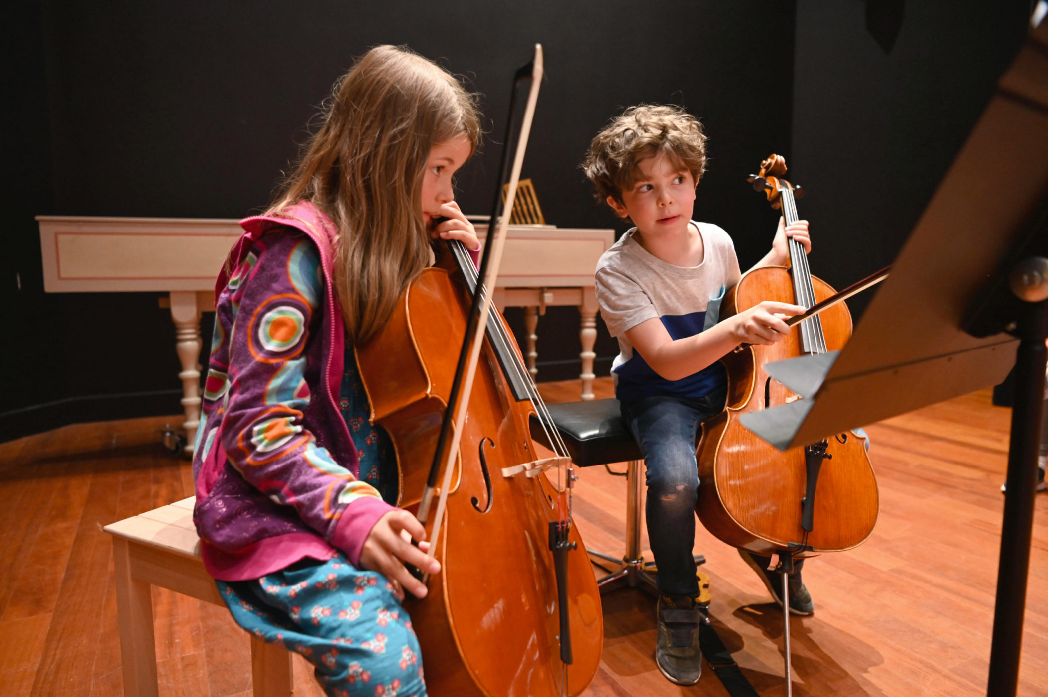 deux enfants jouent d'un instrument à corde dans le cursus interdisciplinaire de musique et théâtre