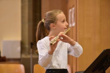 une élève du conservatoire populaire joue de la flûte traversière en cours