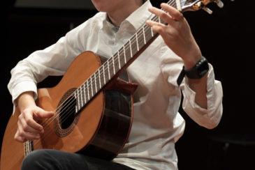 un élève apprend à jouer de la guitare dans un cours à genève