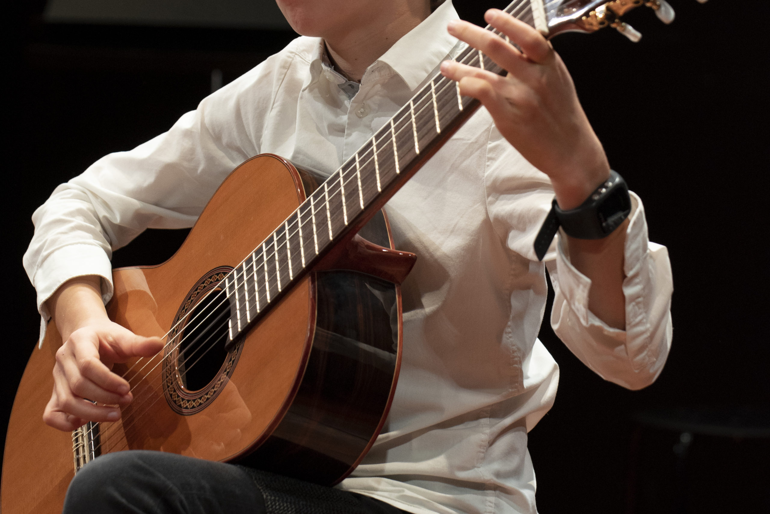 un élève apprend à jouer de la guitare dans un cours à genève