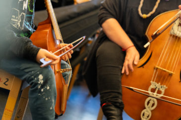 zoom sur des mains qui jouent de la viole de gambe en cours